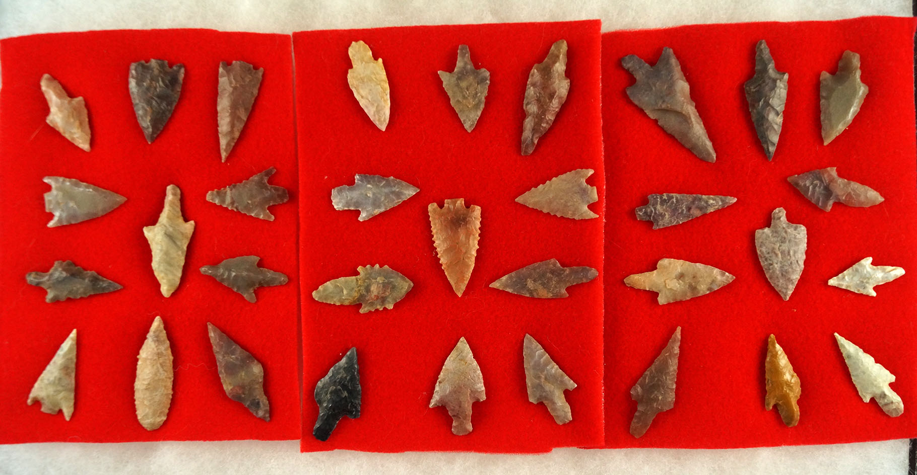 Large group of approximately 33 African Neolithic arrowheads glued to felt, largest is 1 5/8".