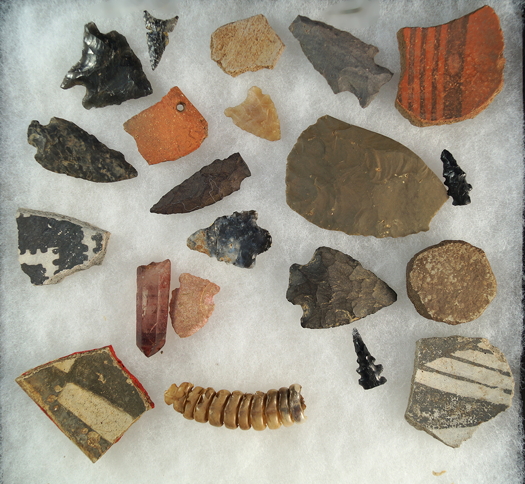 Assorted artifacts including arrowheads and pottery shards, a pottery discall found in Arizona.