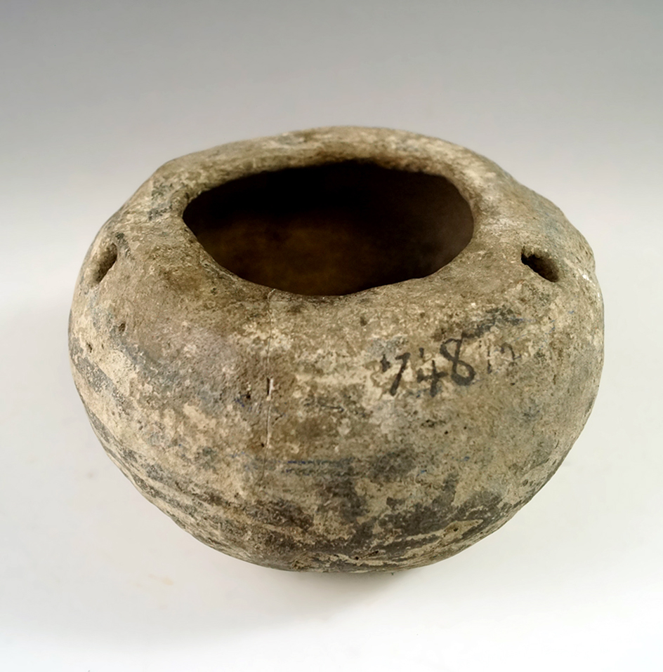 3 3/4" diameter restored and broken and glued pottery vessel with label tags that say South Dakota.