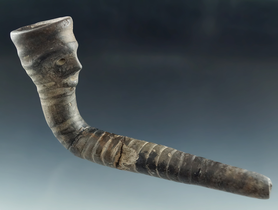 6" human effigy Iroquois clay pipe which was broken and reglued at the elbow - some restoration.