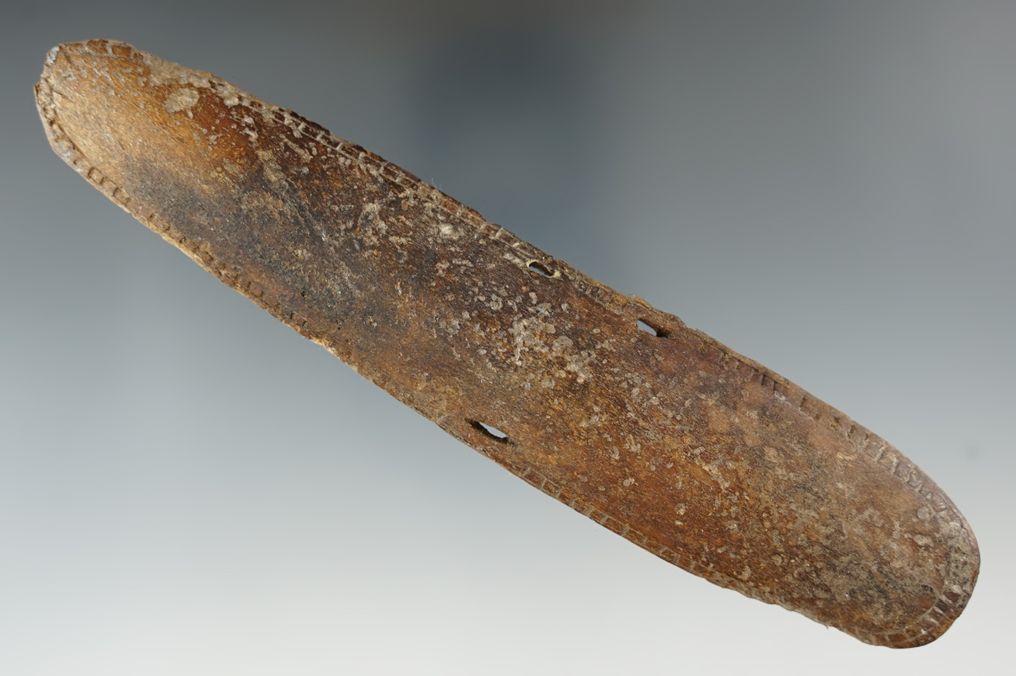 6 5/16" heavily patinated bone Inuit wrist guard with nice engravings around all edges.