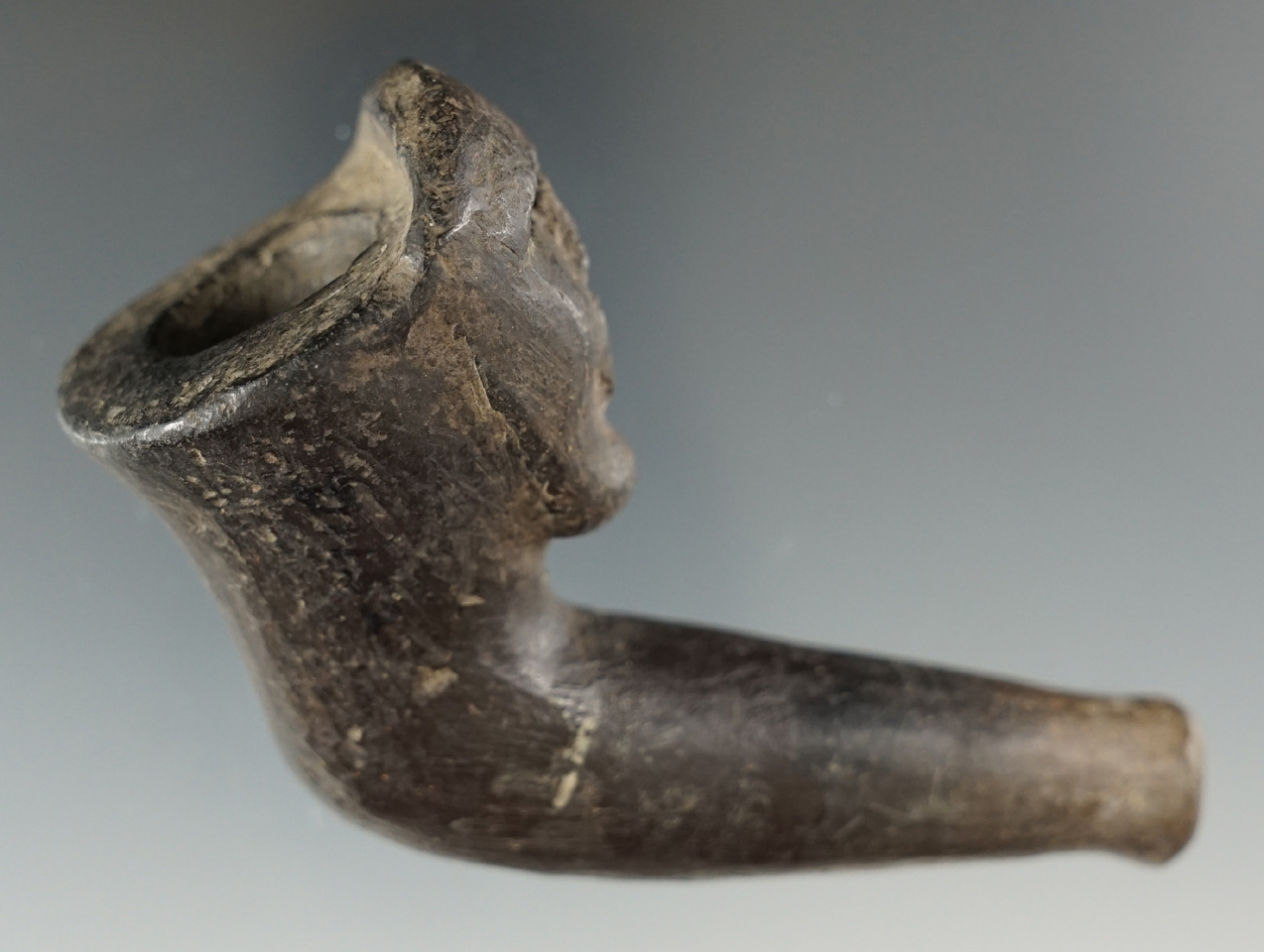 3 5/8" by 2 3/8" Iroquois clay human effigy pipe with a broken and mended elbow.