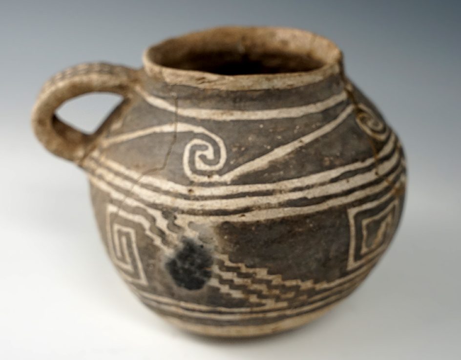 5 3/4" wide nicely decorated Southwestern strap handle jar. A few reglued pieces.