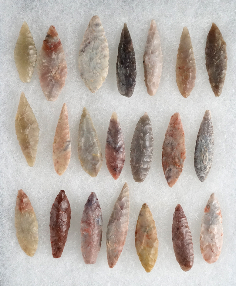 Set of 20 assorted colorful African Neolithic arrowheads found in northern Sahara desert region.