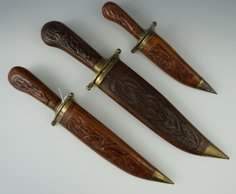 Unique set of three matching knives from India with ornately carved wood handles and sheaths.