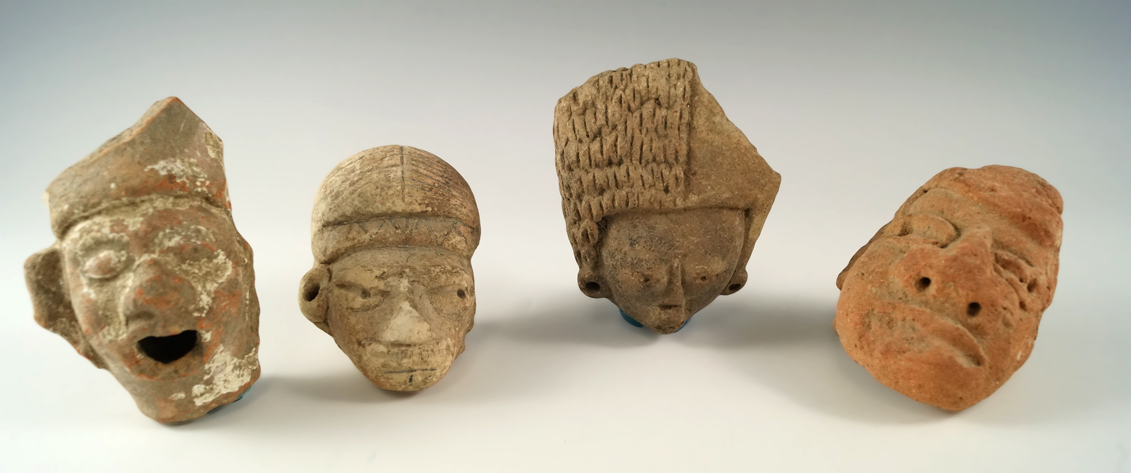 Set of four larger Pre-Columbian Mesoamerican pottery heads, one is broken and glued.