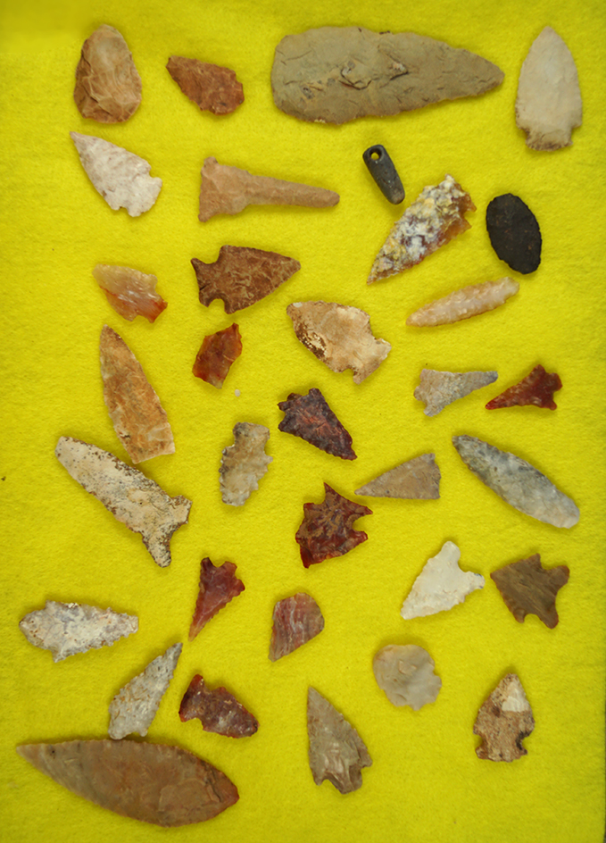 Large group of arrowheads and knives found in Arizona by Kay Brewer. Includes a stone pendant.