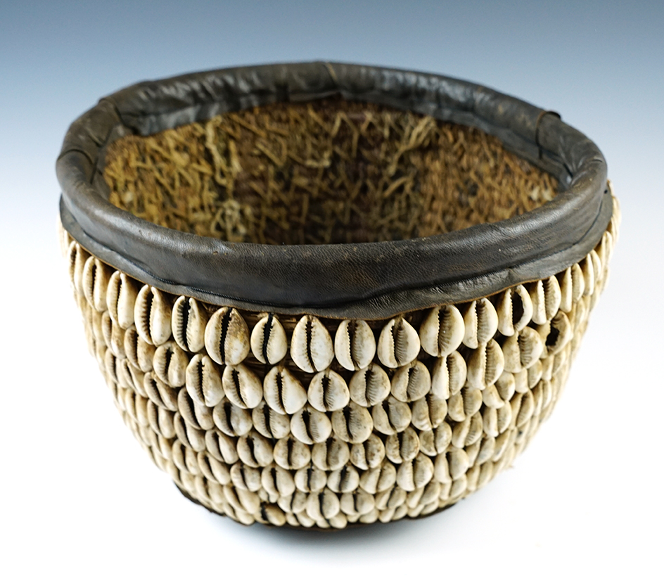 7" tall x 9 1/2" wide African basket that is highly decorated with cowrie shells.