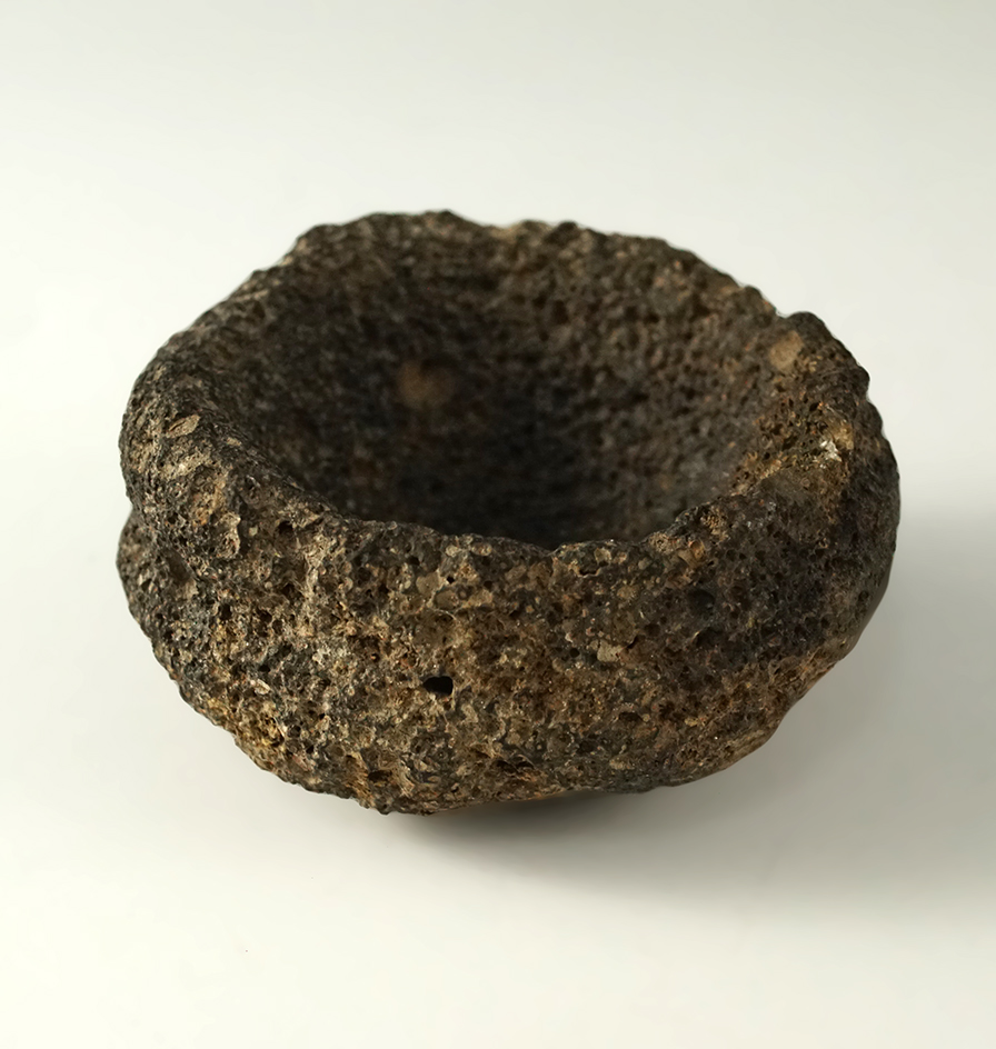 Miniature paint pot with a line cut around the top, scant residue of red ochre inside.