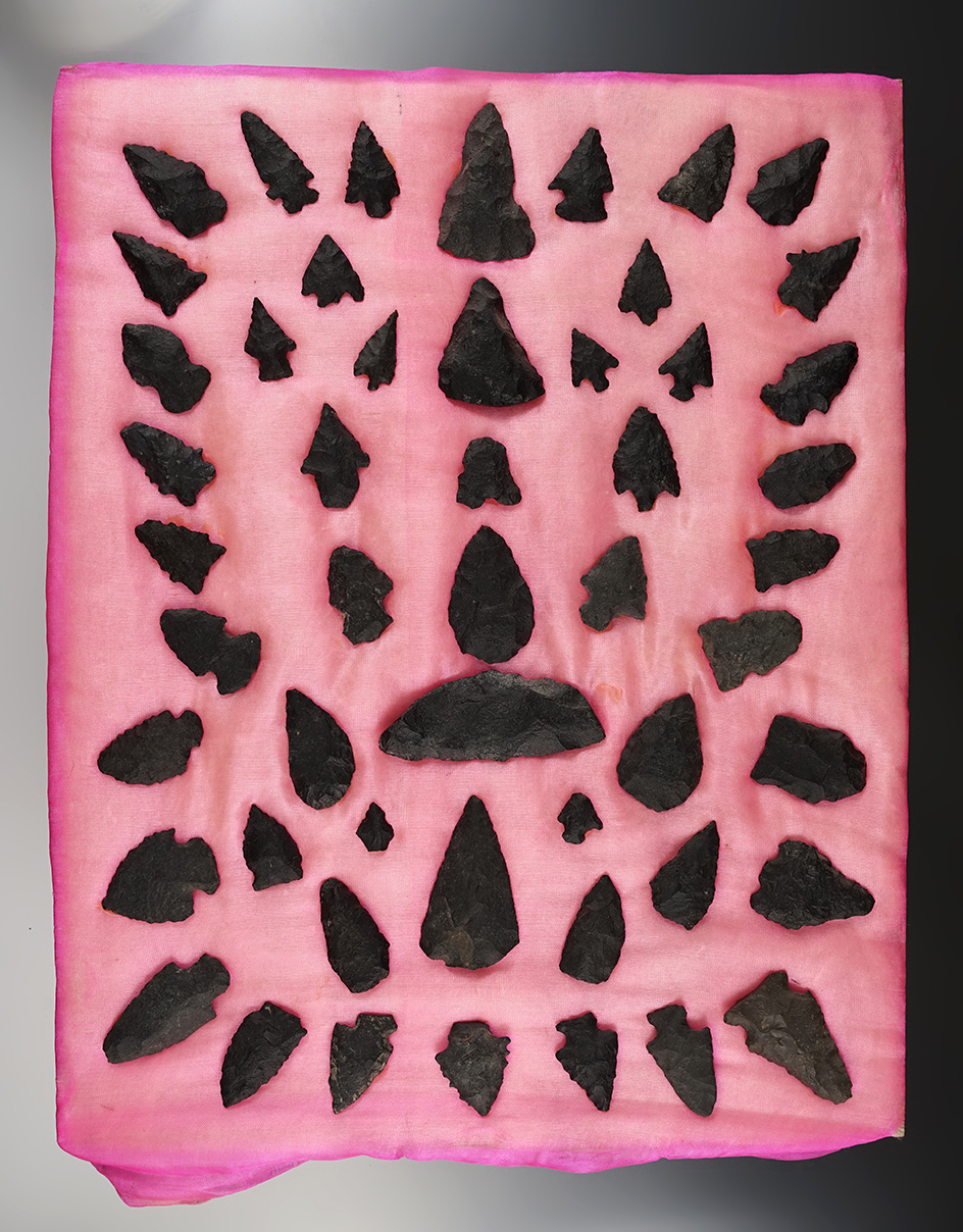 Group of assorted basalt points and knives glued to an old display board. Found in New Mexico.