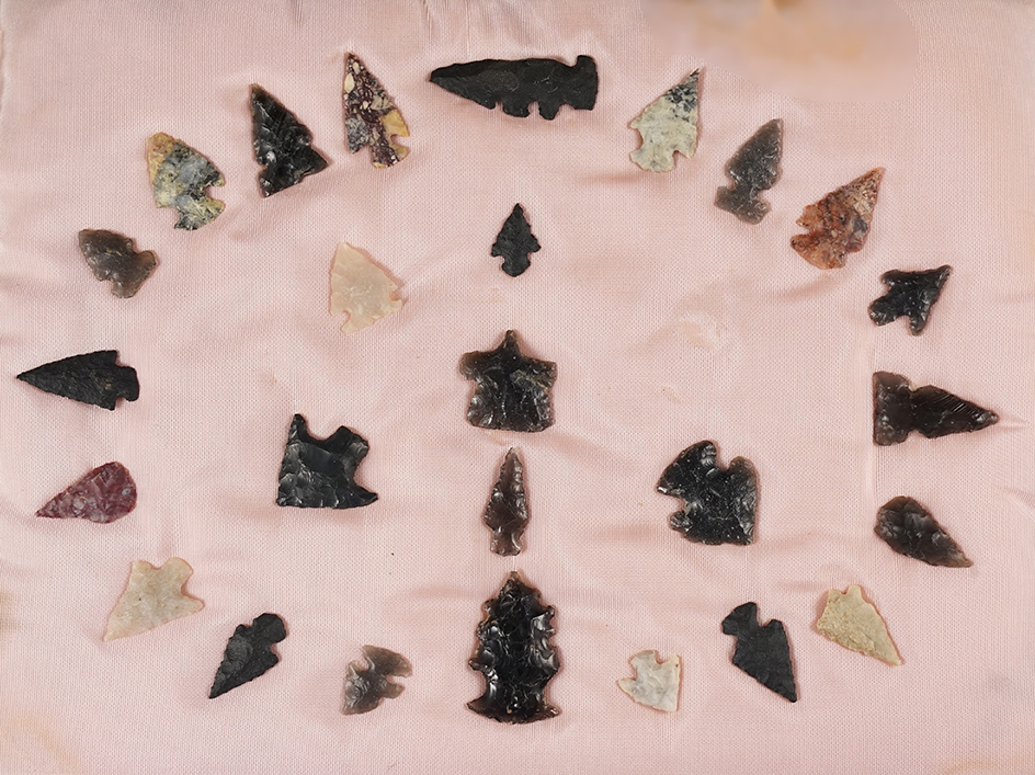 Group of 25 arrow points that were surface found in New Mexico glued to a board.