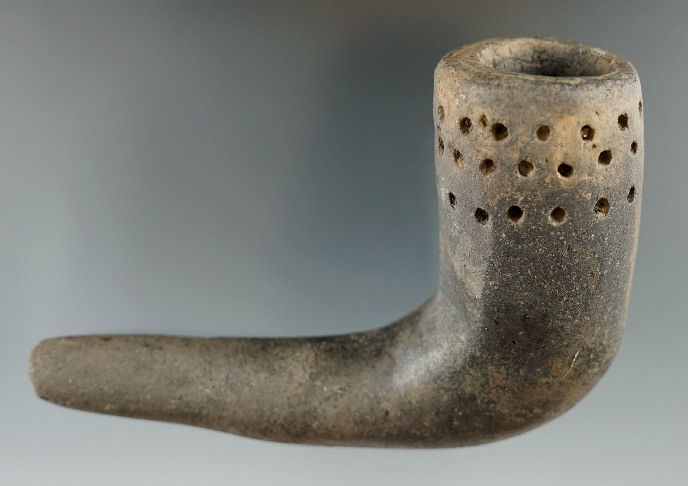 4" late woodland clay pipe with punctate bowl design found in New York. Restoration to elbow.