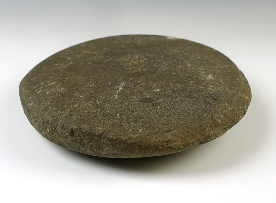 7 7/8" Stone worked into a circular shape with a nutting divot in the middle. Found in Western Ohio. 