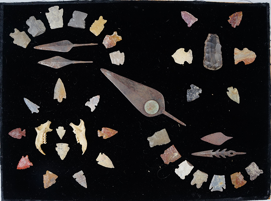 Set of assorted Colorado points, metal and tools. All are glued to a felt-covered board.