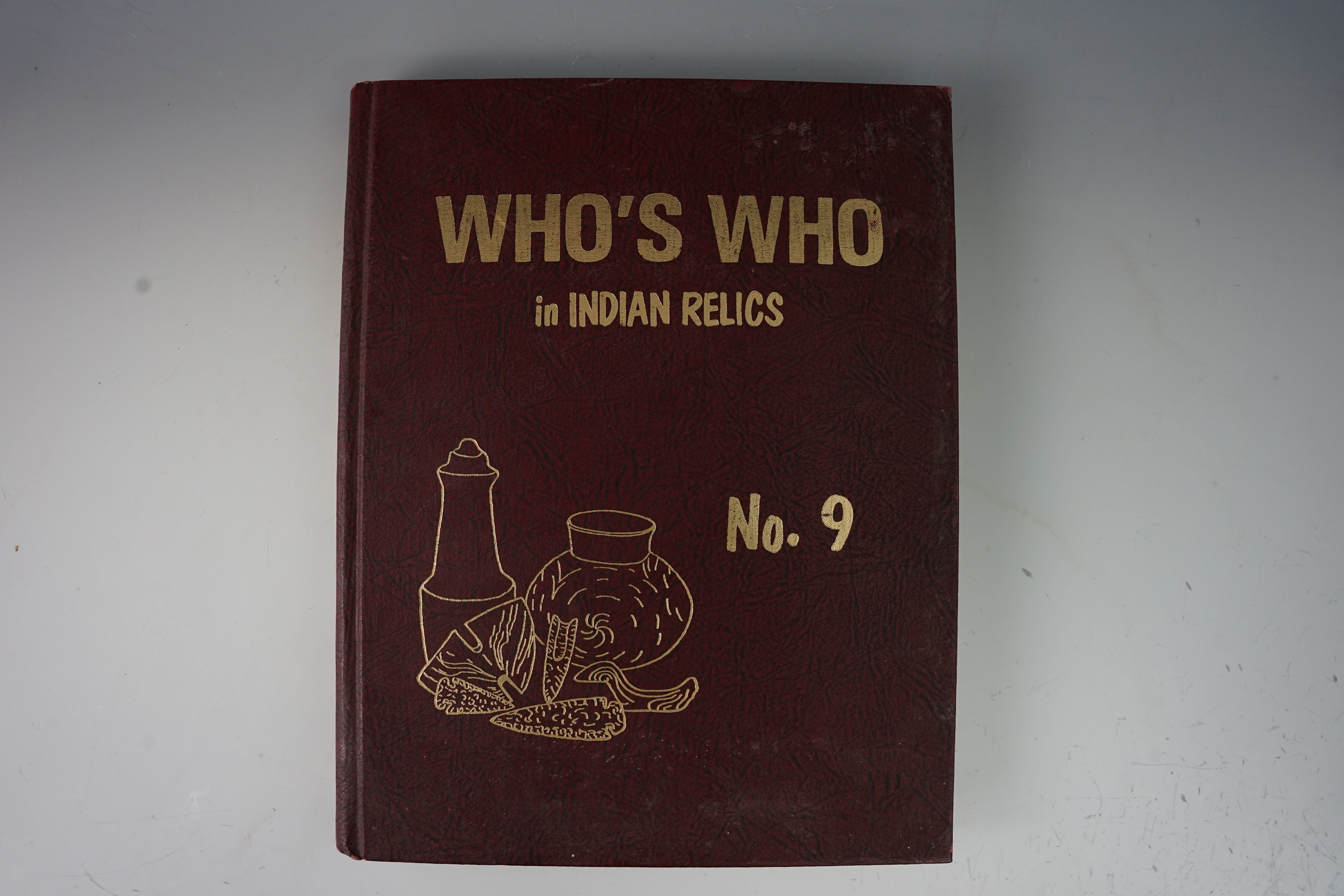 Hardcover book "Who's Who in Indian Relics #9". Cover shows some wear, interior pages like new.