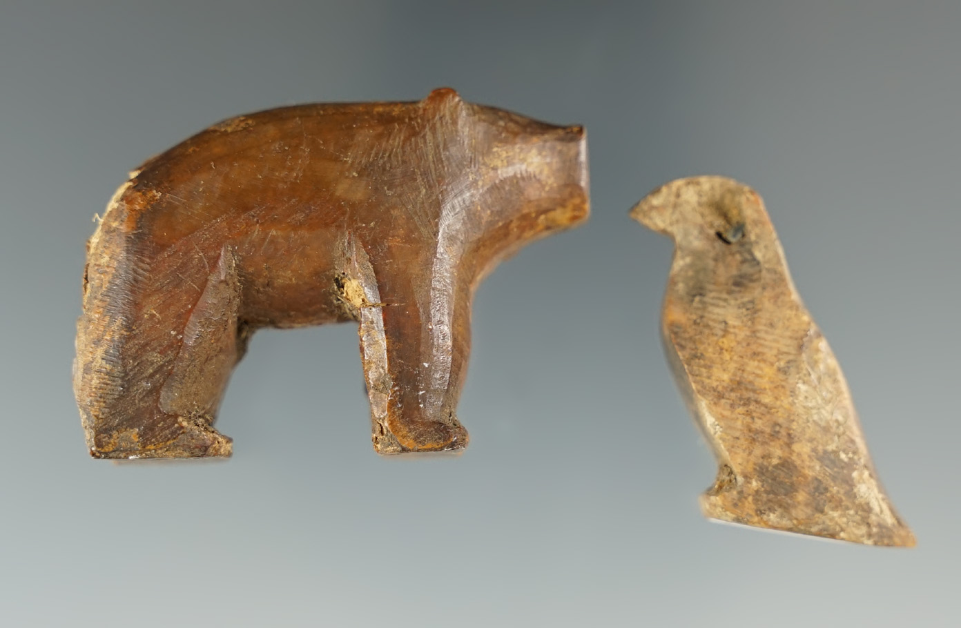 Pair of Inuit carved ivory figures including a 1 3/4" bear and a 1 1/8" tall penguin/bird.